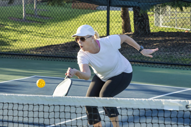 Female Pickleball Player Returns Volley